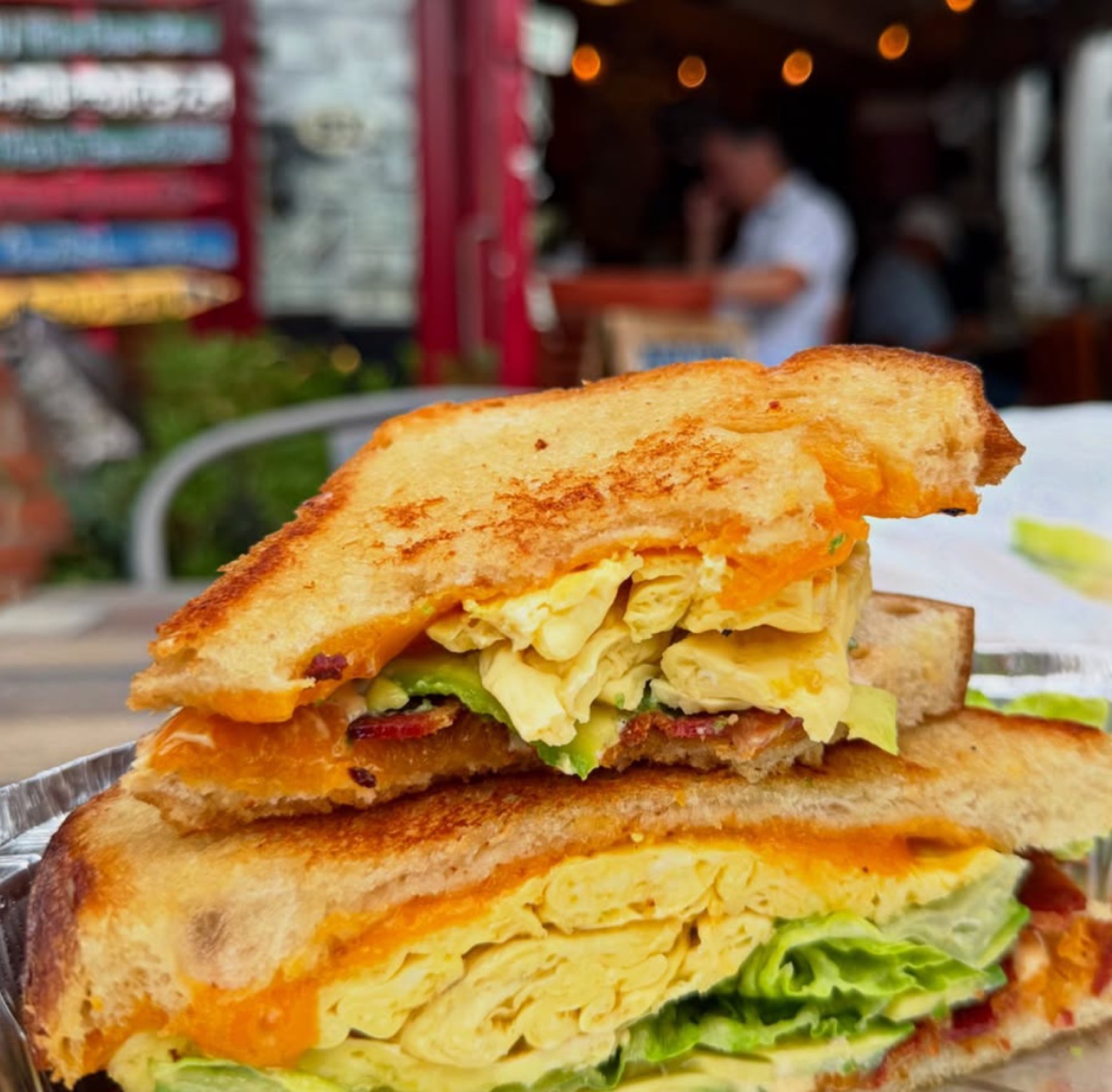 Grilled sourdough breakfast sandwich with egg, bacon, and avocado