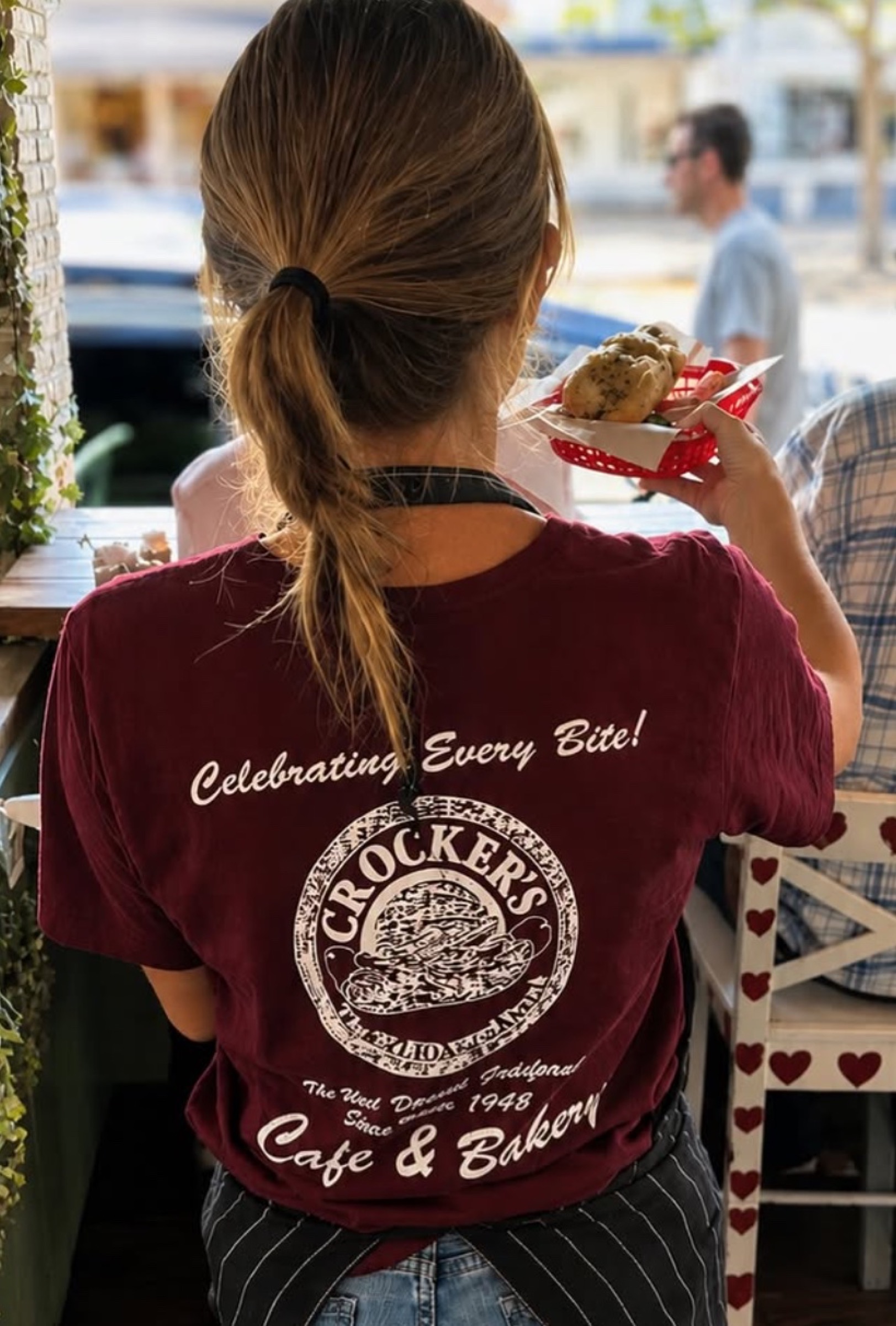 Crocker's staff member wearing a burgundy t-shirt reading Celebrating Every Bite